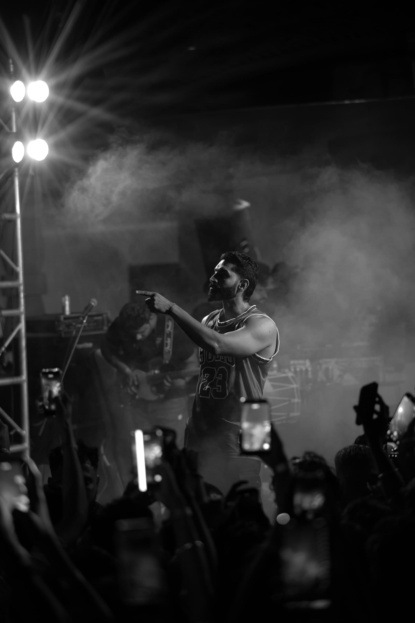 Black and white — the crowd's phones raised toward the stage