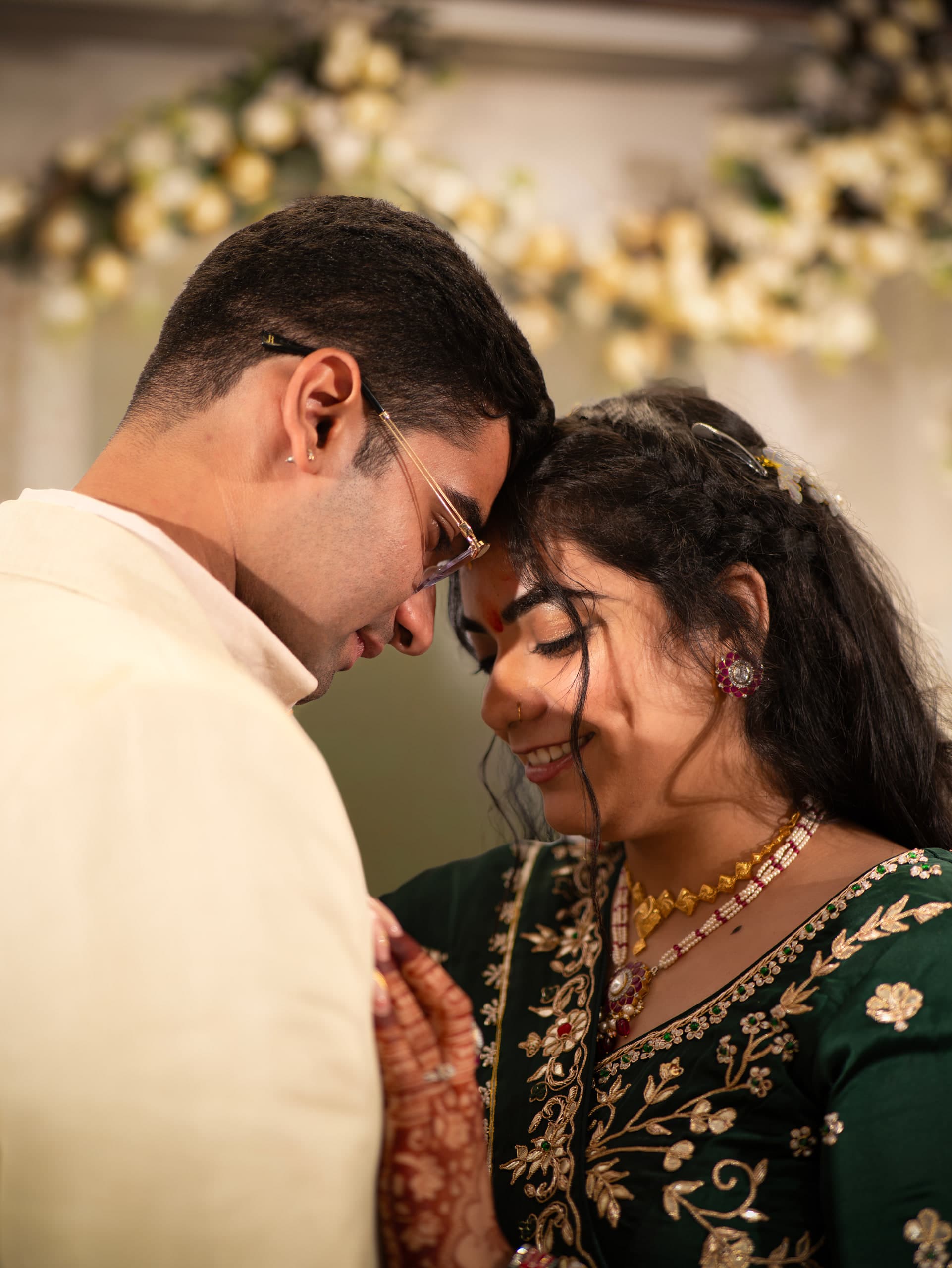 Couple leaning together, foreheads close, eyes down