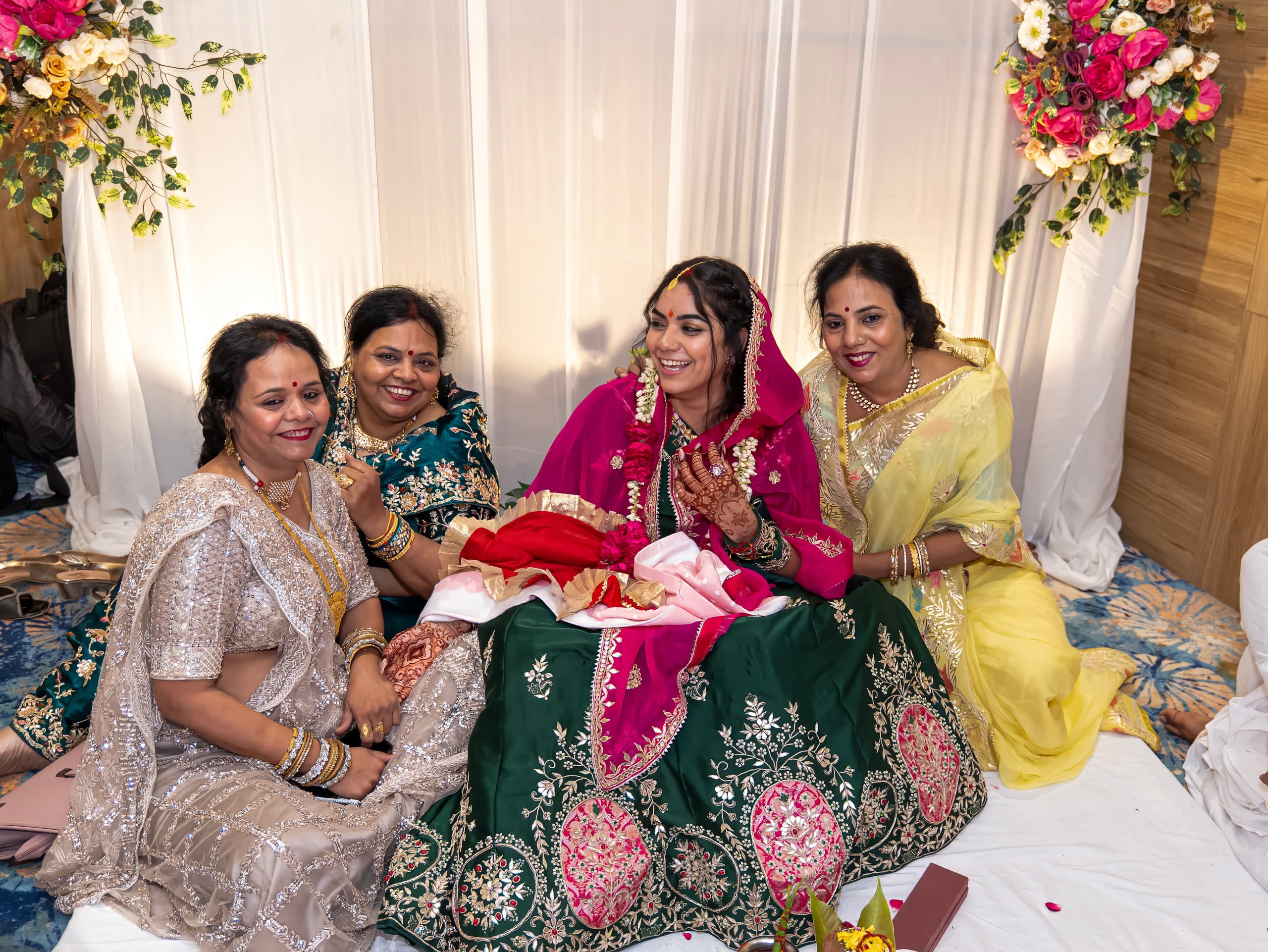 Family group seated around the bride, all in bright silks