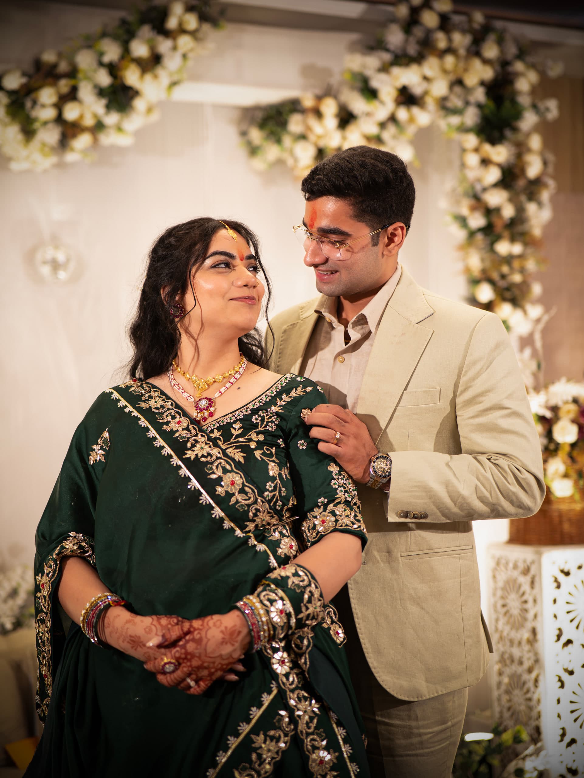 Bride standing in green with the groom close behind her