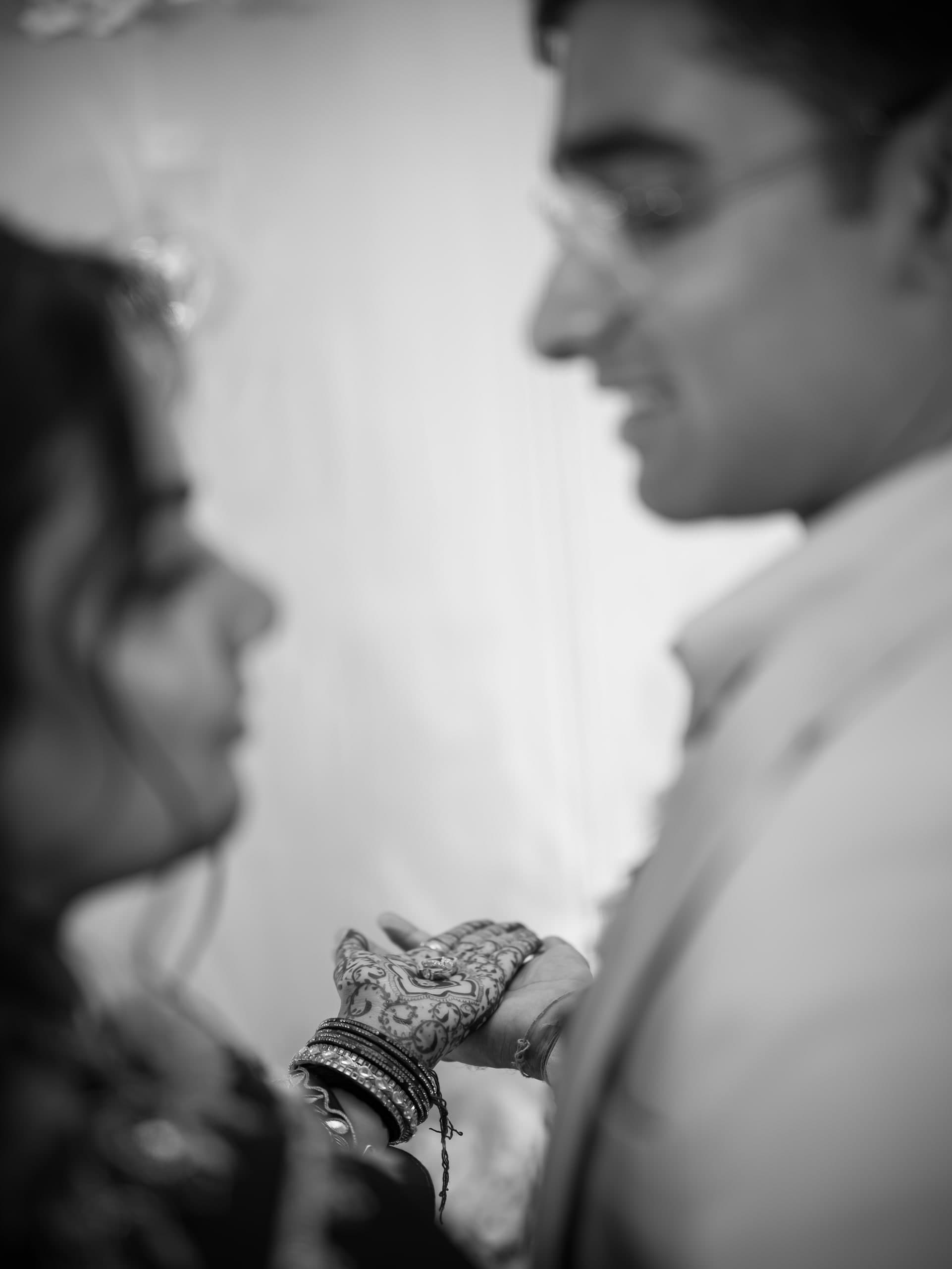 Black and white — the couple in profile, her bangled hand held between them