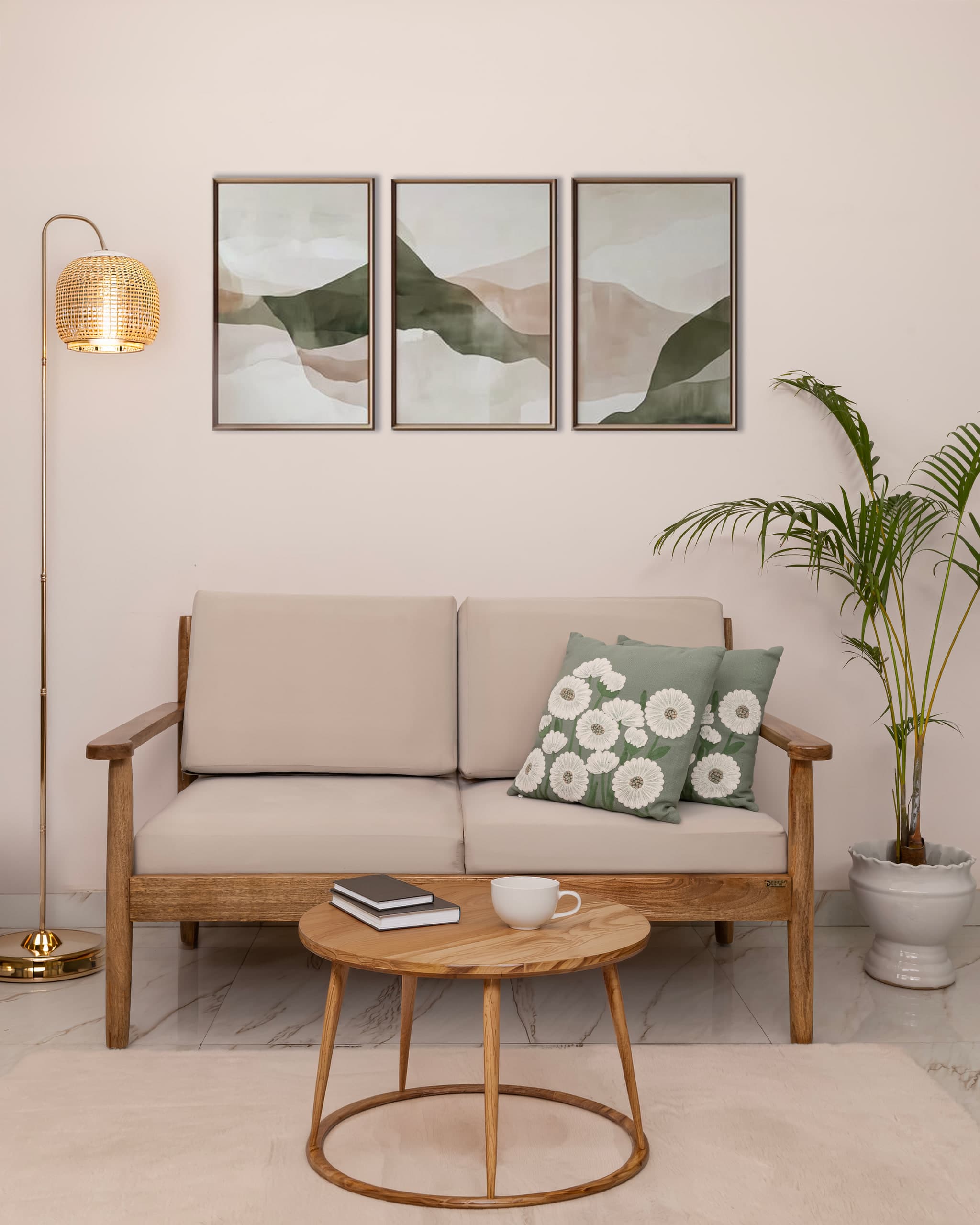 Wooden-framed sofa under three framed landscapes, brass floor lamp to one side, palm to the other