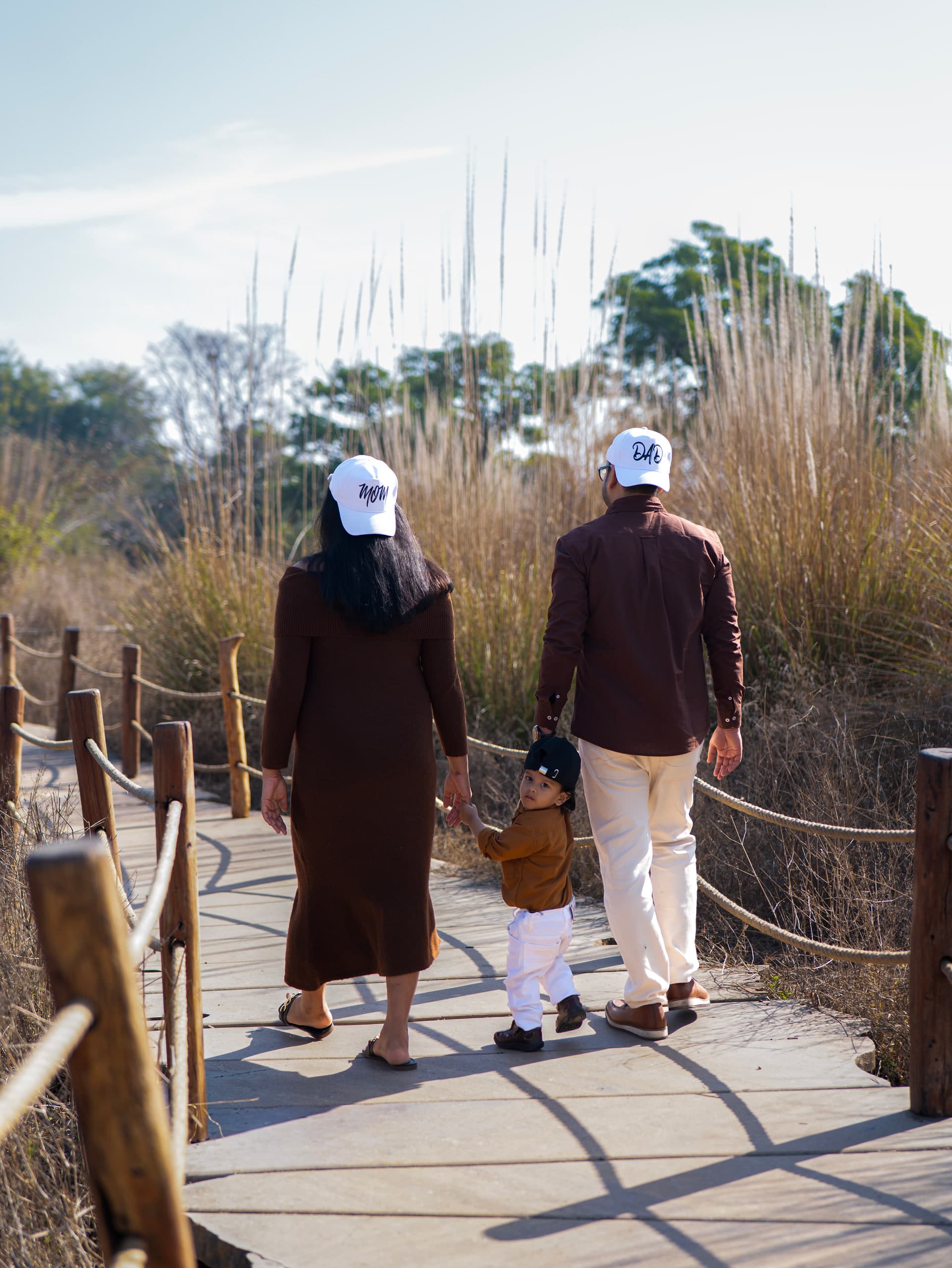 Couple walking away along a boardwalk through tall reeds
