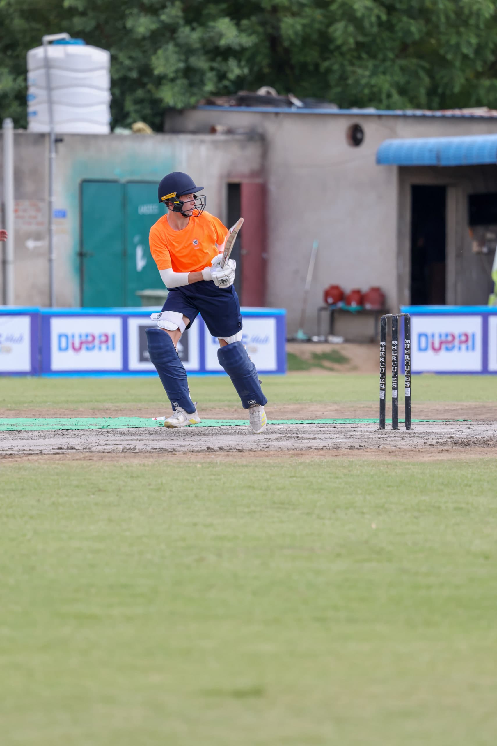 Batter setting off for a run, bat trailing, helmet turned to watch the ball
