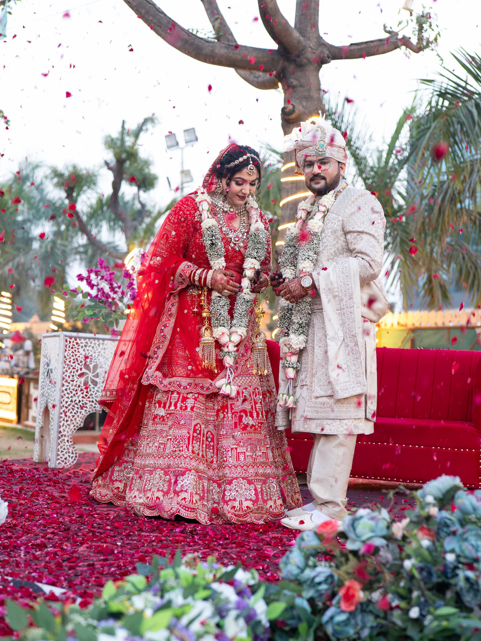 Couple showered with rose petals, both mid-laugh