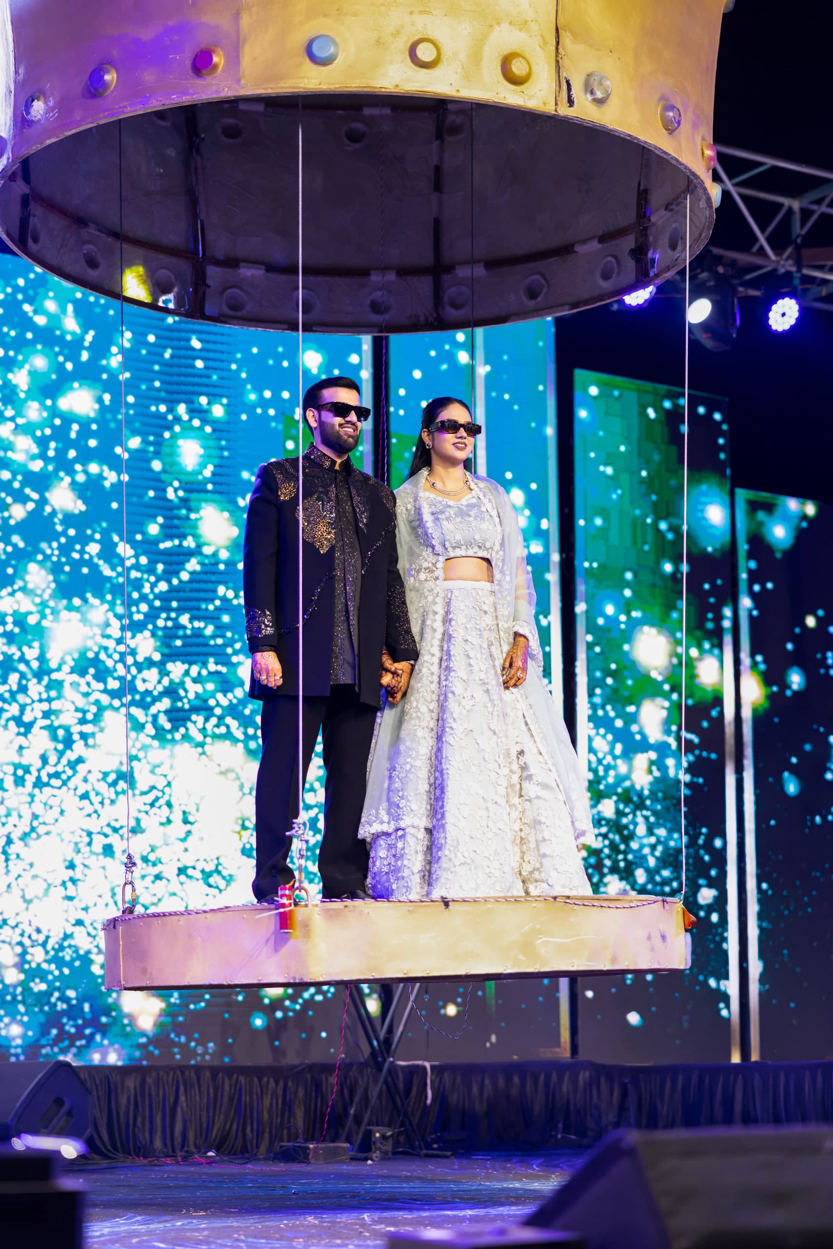 Couple on a lit stage, blue and white sparkle filling the background